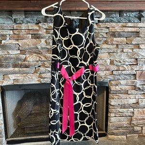 Sleeveless dress with pink tie around the middle.